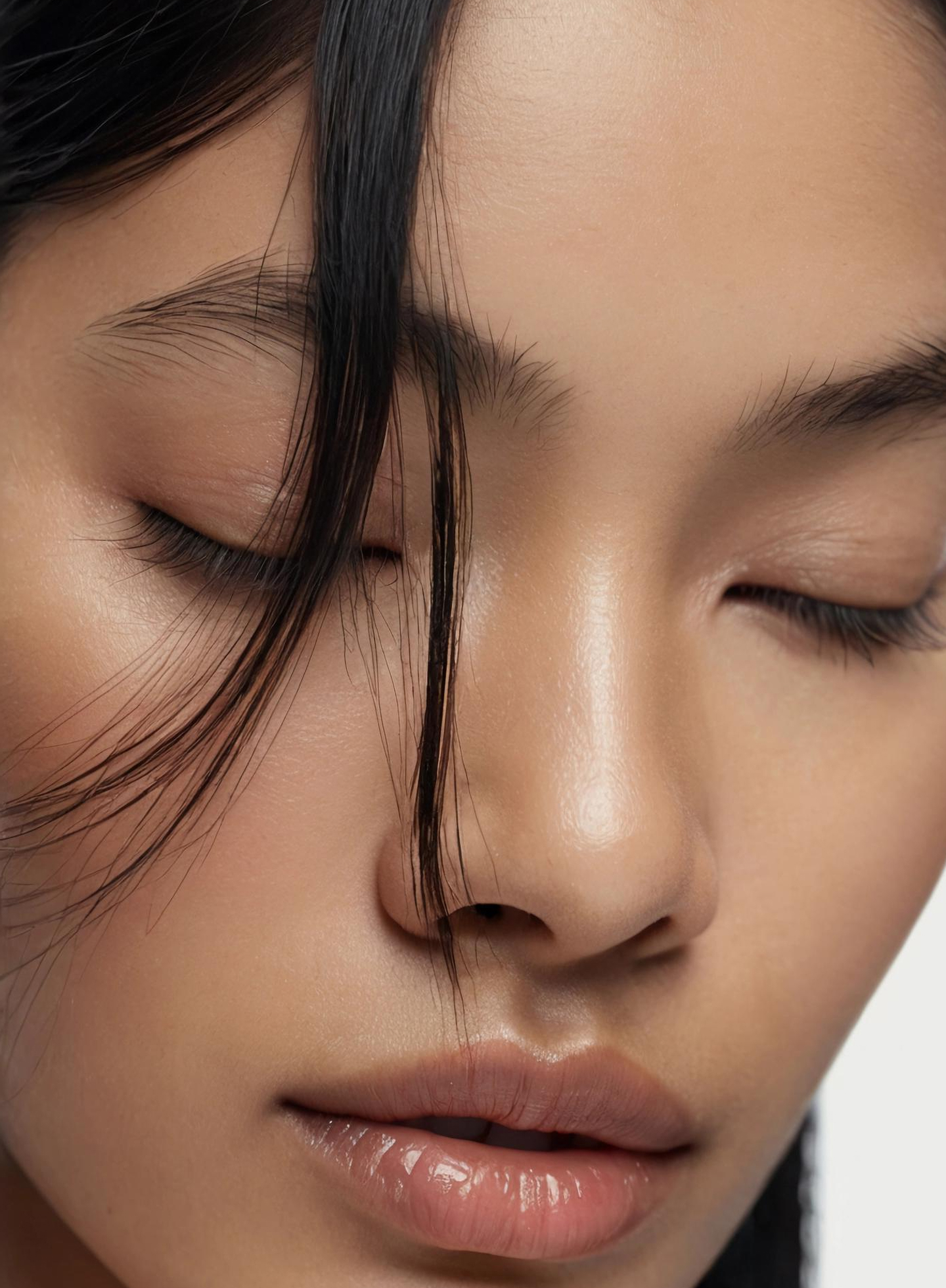 Close-up of a face with loose strands of hair and smooth, even skin